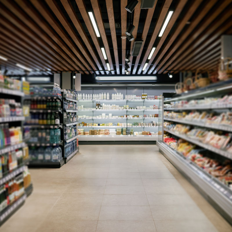 A grocery associate reviewing the shelf set on a tablet